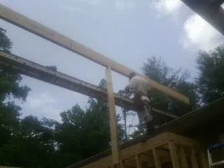 Carpenter setting a ridge beam over a new addition frame — Ice Dam Removal by Roofing Brothers in Dorena
