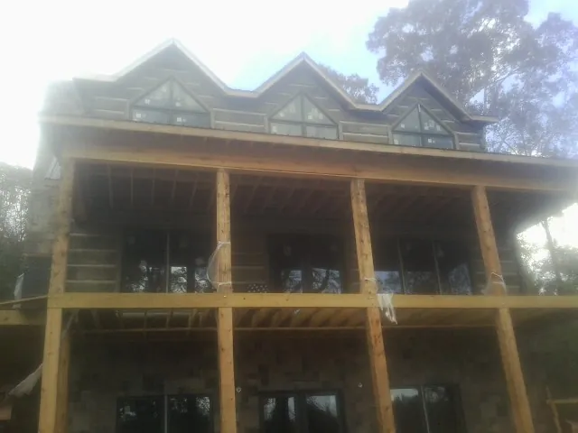 Dormers and porch framing on a large log home under construction — Roof Coating work by our crew in Dorena