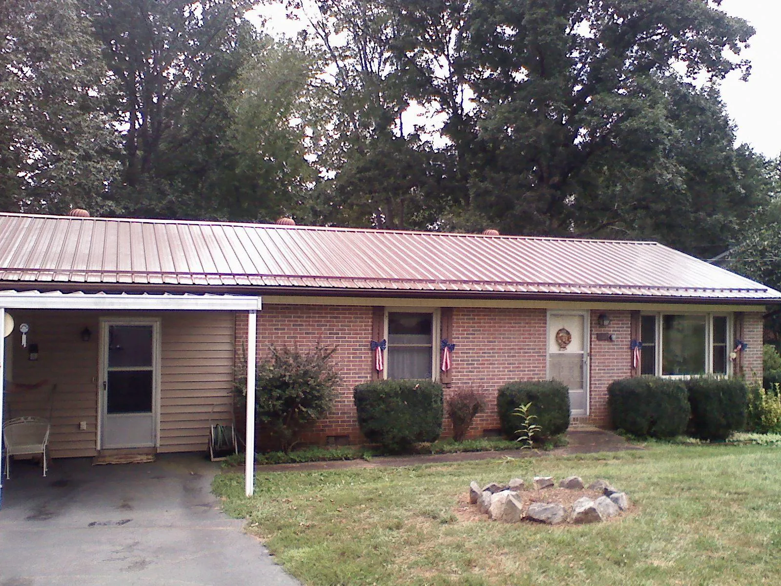 Bronze metal roof and carport on a brick ranch home — Roof Repair work by our crew in Dorena
